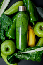 Close Up Green Vegetables And Smoothies In A Plastic Bottle On Black Background. Healthy Concept. Top View