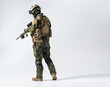 Full length side view serene defender in army clothes keeping assault rifle. Protection concept. Copy space