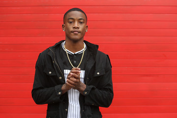 Portrait of a young African American male in expressive movement photo series on red background