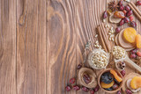 Fototapeta Mapy - Mix of nuts, dried fruits, dried rose hips, and spices on a rustic wooden background. Concept of healthy snack. Various nuts and dried fruits.