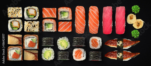 Fotografía Japanese cuisine. Sushi and rolls set over dark background.