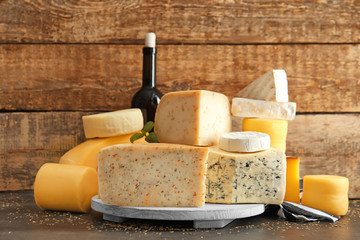 Canvas Print - Wooden board with different kinds of delicious cheese on table