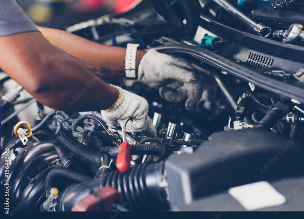Hands of auto mechanic repairing car. Selective focus.