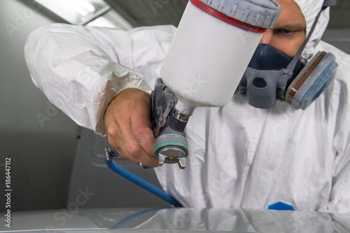 Láminas Painter spray gun in the hands of a painter.