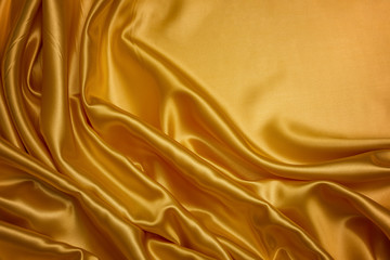 Golden fabric background and texture, Crumpled of yellow satin for abstract