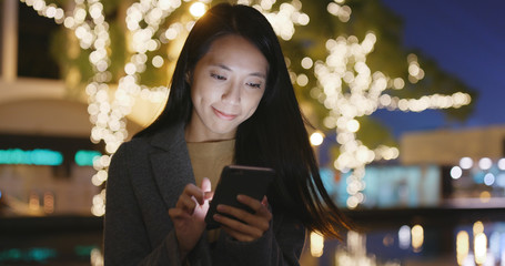 Poster - Woman look at mobile phone in city at night