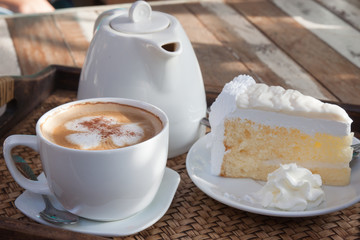 Coffee and cake are placed on a wooden table.