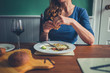 © LoloStock - Young woman eating a meal at table