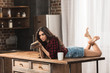 © LIGHTFIELD STUDIOS - sensual young woman with book lying on table with cup of coffee