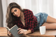 © LIGHTFIELD STUDIOS - seductive girl in checkered shirt holding book and looking at camera