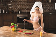 © LIGHTFIELD STUDIOS - sexy woman in lingerie and towel holding knife and looking at camera while cooking at home