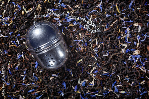 Fotografia, Obraz Loose leaf tea metal infuser on black tea background with copy space