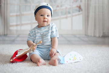 Wall Mural - Little baby boy, playing wtih little boat and little fish at home