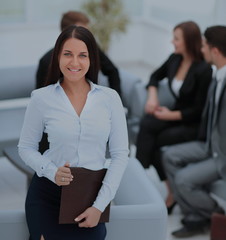 Sticker - Young business woman standing with her collegues in background a