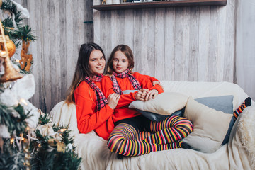 Two girls sisters have relax and fun in a room decorated for Christmas and the New year