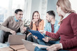 © Viacheslav Yakobchuk - Good company. Pleasant joyful perspective employees sitting in the office by the table overlooking the document and working with theirs laptops.