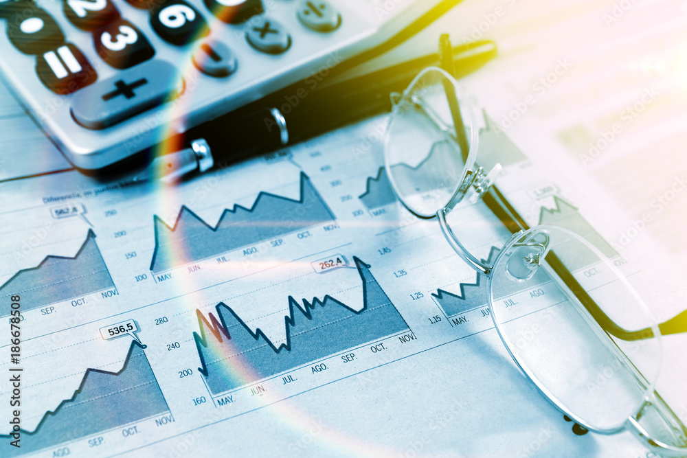 Datos de mercado y comercio de bolsa.Fondo de economia y finanzas.Pluma,gráficos y gafas