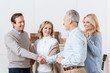 © LIGHTFIELD STUDIOS - Couple of middle aged man and woman greeting their friends as guests and shaking hands