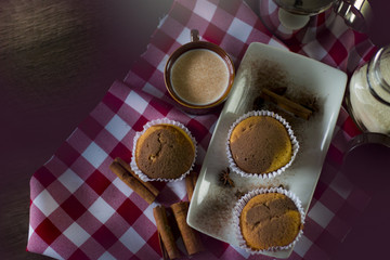 bolinho fofo com cafe e leite encima de uma mesa de rustica de madeira remetendo ao interior de Minas Gerais.