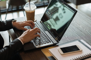 Poster - Close-up of male hands using modern laptop in coffee shop.