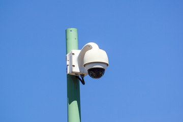 High tech overhead security camera with a blue sky