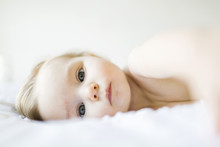 Portrait Of Baby Girl Lying On Bed