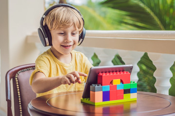 boy in tropics talking with friends and family on video call using a tablet and wireless headphones