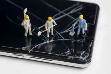 Wall Mural - miniature worker working on cracked smartphone screen