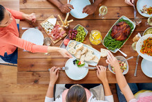 Group Of People Eating At Table With Food