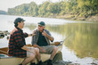 © Cavan Images - Happy friends talking while sitting on boat at lakeshore