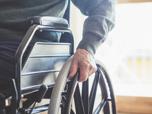 Midsection Of Senior Man Sitting On Wheelchair