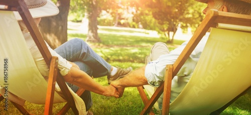 Fotografía Mature couple sitting in deck chairs at park