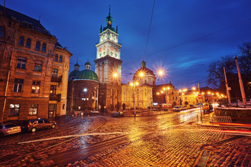 Wall Mural - Scenic view on illuminated Assumption Church Bell Tower at twilight with vintage tram on foreground, Lviv, Ukraine.