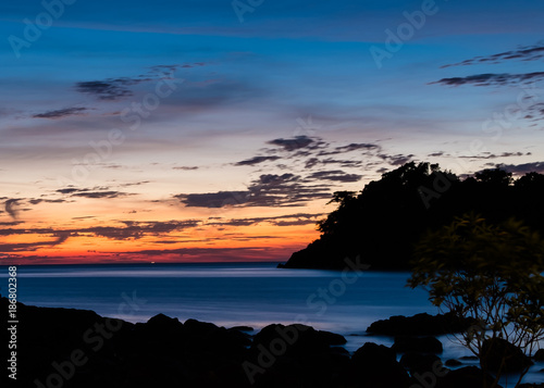 Photographie long exposure shot of sun set in twilight period with silhouette foreground and
