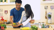 © Kittiphat - Young Asian Couple having fun Preparing Food, vegetable and salad in the Kitchen