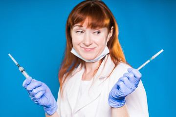 The doctor chooses syringes for injection, smiling