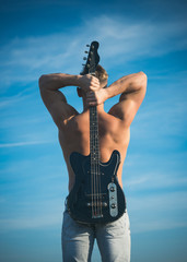 Wall Mural - Sportsman with muscular back hold electric guitar