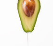 Dripping oil on a cut avocado on a white background