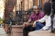 Couple Sit And Talk On Stoop Of Brownstone In New York City