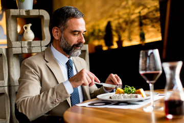 Senior man eating lunch in restaurant