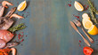 Top view on fresh seafood and fish with fish knife and fork on a blue wooden background with copy space.