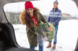 © pikselstock - Couple Loading Freshly Cut Down Christmas Tree Into Back Of Their Car