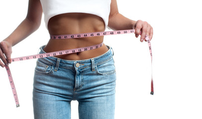 Wall Mural - Woman is measuring waist after weight loss.