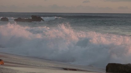 Wall Mural - shorebreak ocean waves near rocky coast and cliffs, rough sea water at sunset time