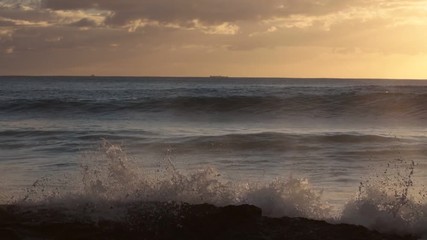 Wall Mural - shorebreak ocean waves near rocky coast and cliffs, rough sea water at sunset time