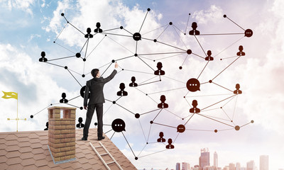 businessman on house roof presenting networking and connection concept. mixed media