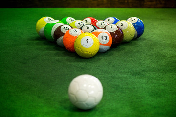 Wall Mural - Shot of foot pool balls standing on green table. Foot Pool is the hybrid combination of pool and soccer. Big billiard balls