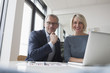 © Westend61 - Businessman and woman working together in office using laptop