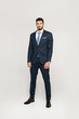 © LIGHTFIELD STUDIOS - full length view of stylish handsome young businessman looking at camera isolated on grey