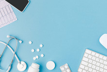 Container, Scattered Pills, Stethoscope, Cardiogram, Keyboard And Smartphone Isolated On Blue Background